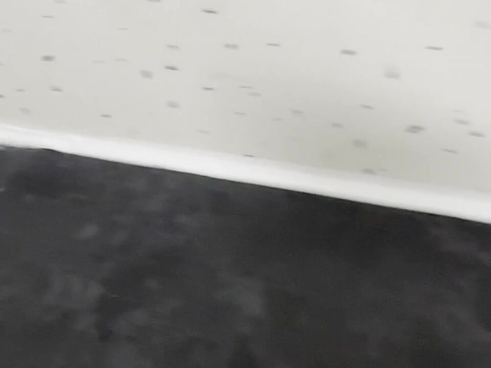 A straight, even line of white sealant between the wall panel and the black worktop