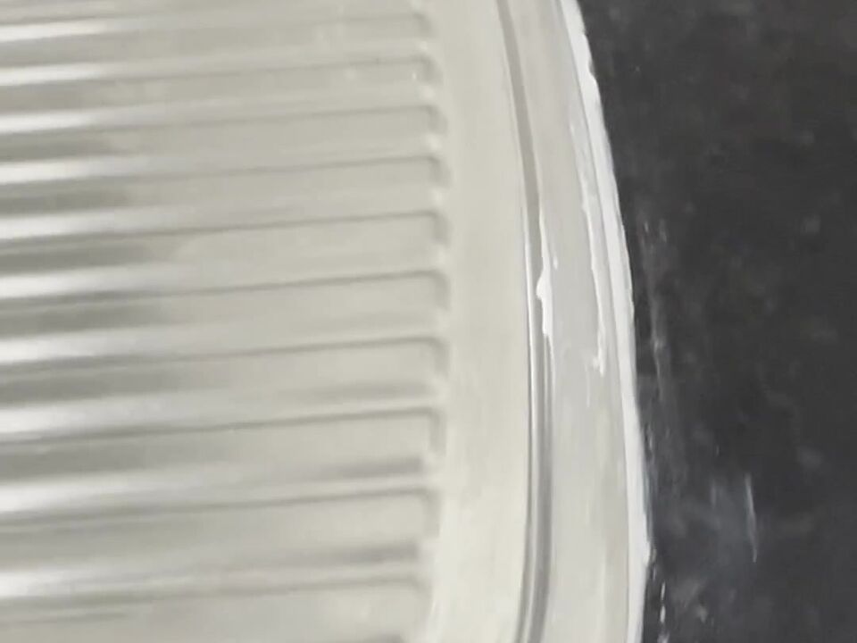 Lumps and smears of white sealant on the steel rim of the sink drainer